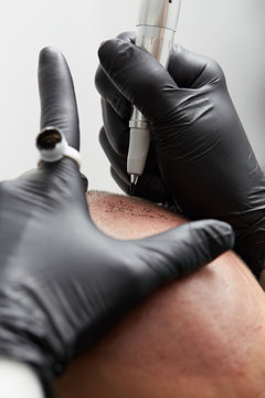 professional tattooist making permanent make up on man skin head - Tricopigmentation