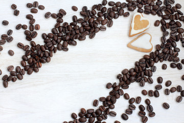 date with gusto/ couple cookies in the shape of heart in coffee beans scattered on the table top view 