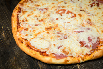 Top view of Italian rustic PIZZA on wooden table background