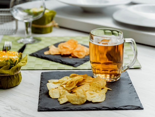 Beer and chips on the large white table