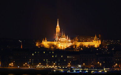Obraz premium View on the illuminated Fisherman's Bastion on a winter night, surrounded by many lightened windows. Budapest.