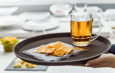 Beer and chips on the large dish.