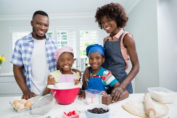 Parents and kids preparing food in kitchen at home