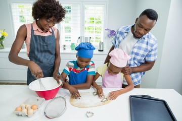 Parents and kids preparing food in kitchen