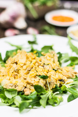 Red Lentils Dish with Mushrooms and Fresh Wild Rockets Leaves on White Plate. Shallow Depth of Field Side View.