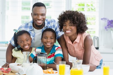 Kids and parents having breakfast on table at home
