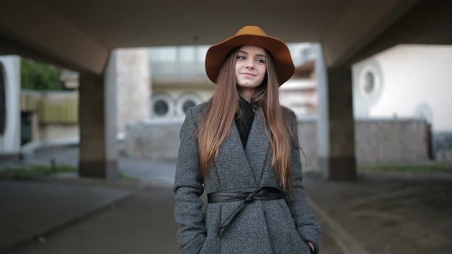 Young Beautiful Girl In A Brown Hat And Coat.