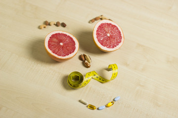 Fitness and healthy life concept. Fruits, nuts, and supplements on a wooden table. Human face pattern.