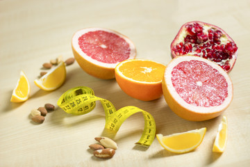 Fitness and healthy life concept. Fruits and nuts on a wooden table. Fitness equipment. Measuring tape on a table.