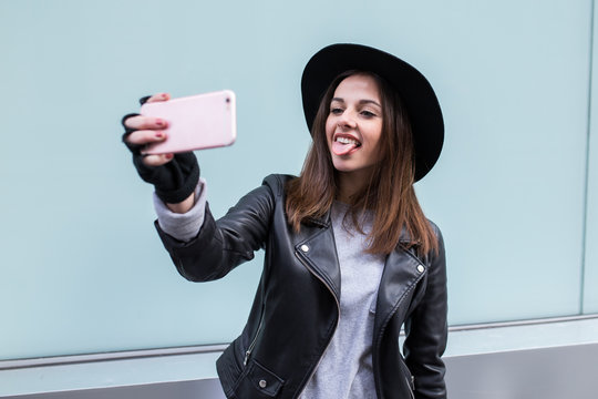 Young stylish woman using a smartphone in the street