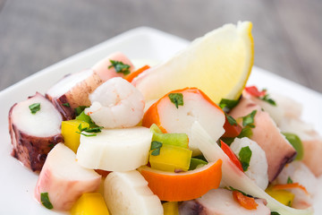 Traditional seafood ceviche from Peru on wooden background
