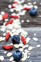 Oat Flakes, Blueberries and Wolfberries Detail on Wooden Background