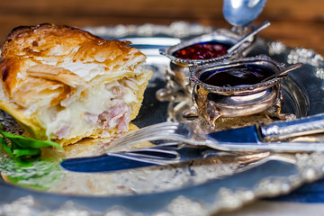 Meat and vegetable pie on the silver plate with sauces
