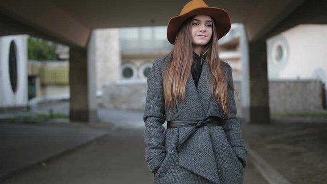 Young Beautiful Girl In A Brown Hat And Coat.