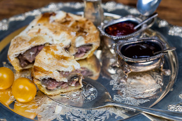 Meat and vegetable pie on the silver plate with sauces