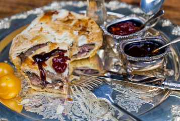 Meat and vegetable pie on the silver plate with sauces