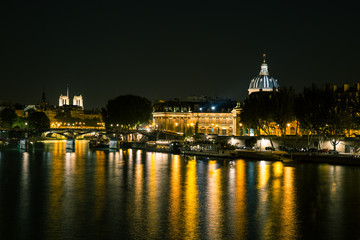 Fototapeta na wymiar Reflections on the River Seine in Paris at night