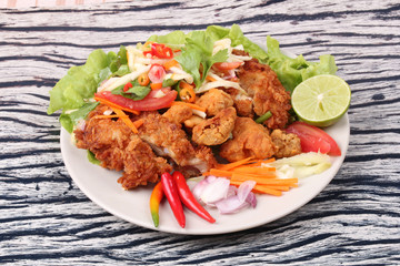 Spicy deep-fried chicken salad with roll green mango .
