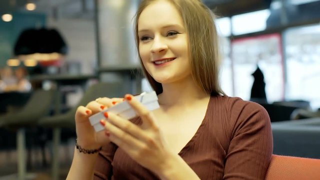 Girl holds box with present inside it and look very happy
