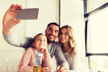 close up of family taking selfie at restaurant
