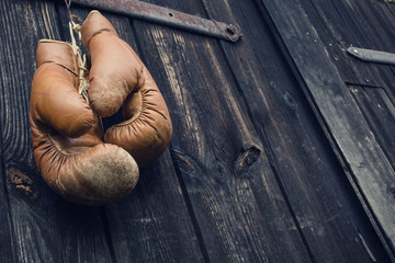 Boxing gloves hanging on old wooden door.