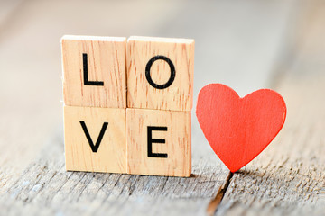 Wooden cubes with word love and red heart on table