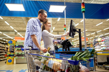 couple buying food at grocery store cash register