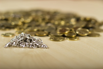 Close up of a digital scale and some gold coins. Silver and gold necklaces by the side. At the jewelers. Pawn shop. Silver and gold on the table.