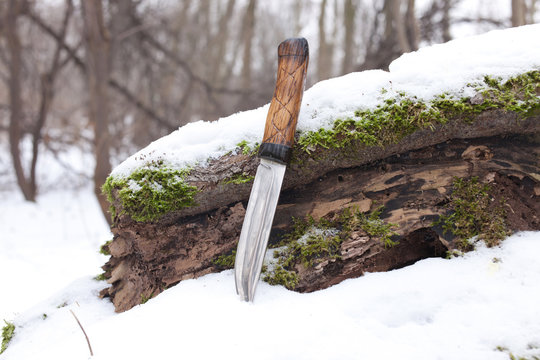 sharp hunting knife, stuck in the snow