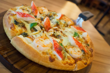 Delicious seafood pizza on wooden table