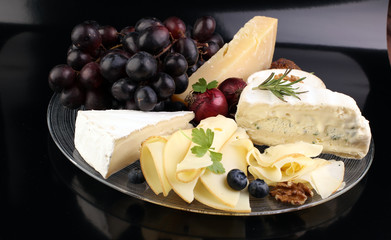 Cheese platter with different cheese and grapes