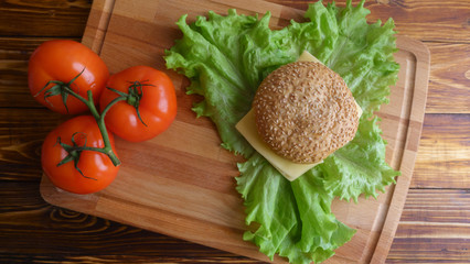 Natural fastfood hamburger top view on salad leaves