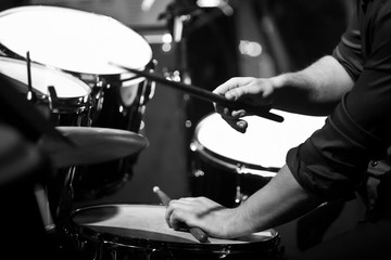 Human hands playing the drum kit in black and white 