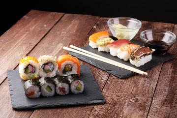 close up of sashimi sushi set with chopsticks and soy - sushi roll with salmon and sushi roll with smoked eel, selective focus.