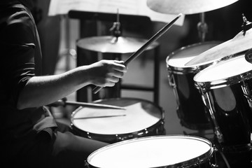 Human hands playing the drum kit in black and white 