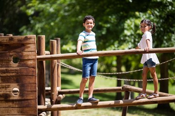 Kids standing on a playground ride in park