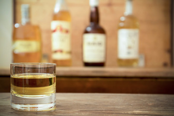 glass with whisky on wooden table