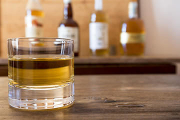 glass with whisky on wooden table