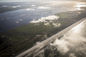 aerial view of the mudflat coastline at low tide with water winding in the mud and sand bank, Frisian island Ameland, The Netherlands