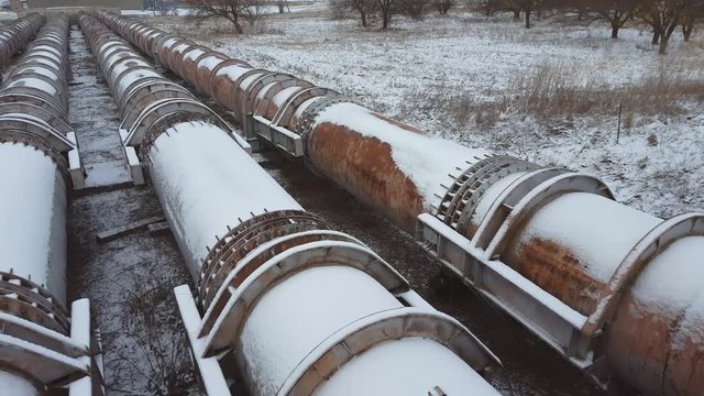 The pipes of the old factory in winter time. Steal big pipeline. Steadicam shot.