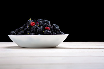 mulberry in white plate, top view