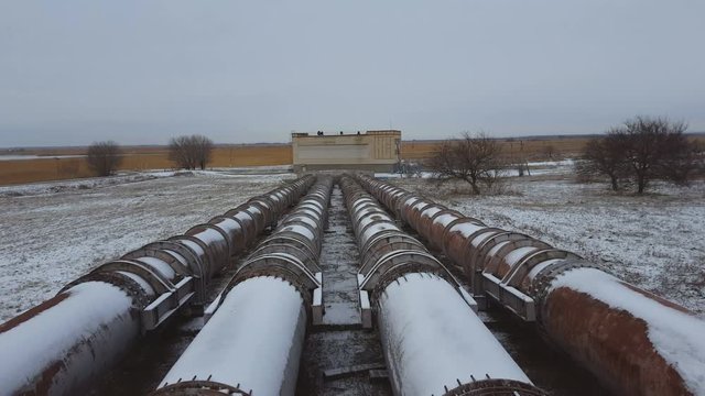 The pipes of the old factory in winter time. Steal big pipeline. Steadicam shot.