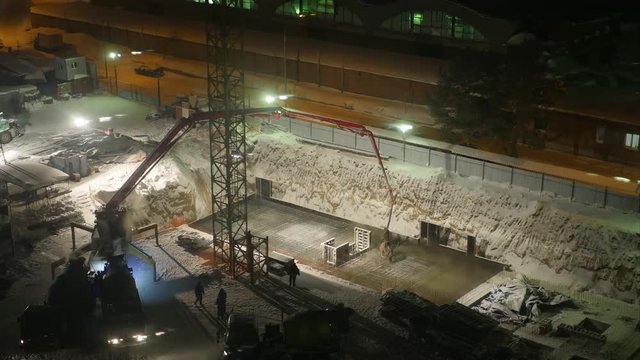 pour cement foundations of the building at night under floodlights, time lapse