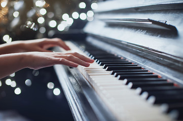 The girl plays piano, close up , white and black keyboard