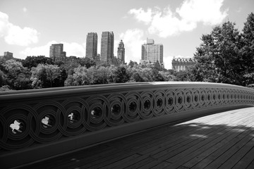 Bow bridge at Central Park and buildings of Manhattan in black and white style, New York