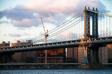 Manhattan bridge and the city with cloudy sunset sky, New York