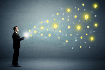 Fototapeta premium Businessman holding lightbulbs