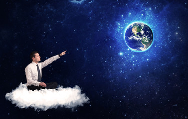 Fototapeta na wymiar Man sitting on cloud looking at planet earth