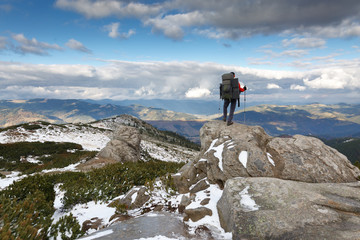 Hiker standing on a rock. Winter landscape.