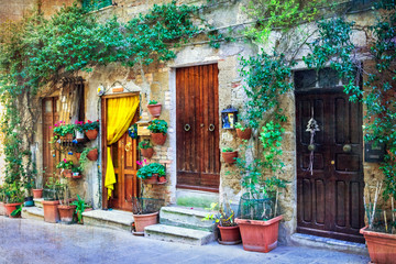 Fototapety  Urocze kwieciste uliczki średniowiecznych miasteczek Włoch. Pitigliano, Włochy. artystyczny obraz w stylu retro